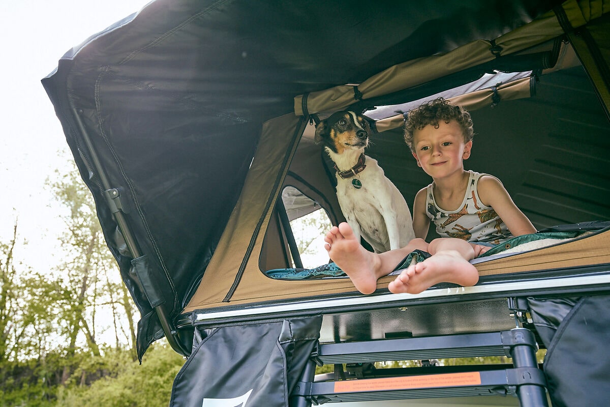 Kind mit Hund im Dachzelt von Vickywood