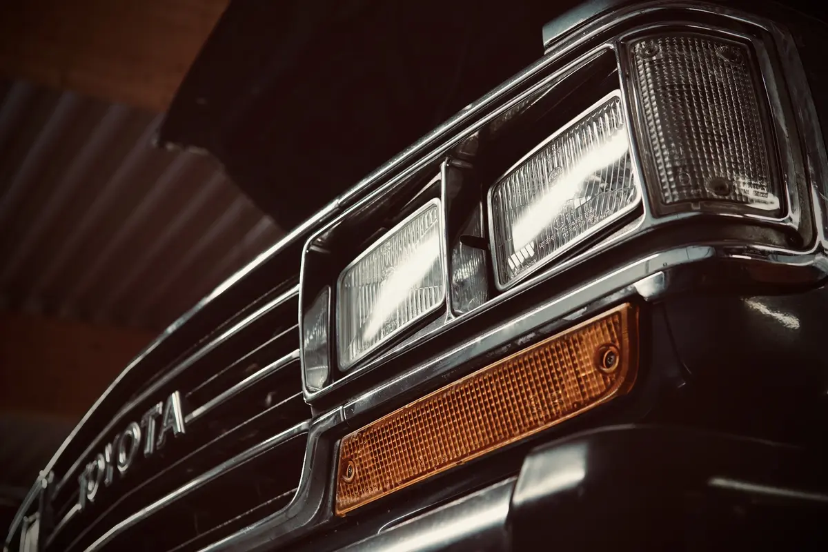 Nahaufnahme der Front eines robusten Toyota 4x4 mit rechteckigen Scheinwerfern und Blinker.