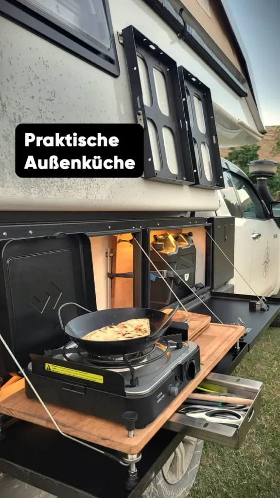 Praktische mobile Außenküche am Expeditionsmobil mit Herd und Besteckschublade.